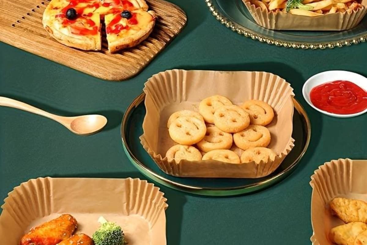 Air fryer paper liners with assorted fried foods.