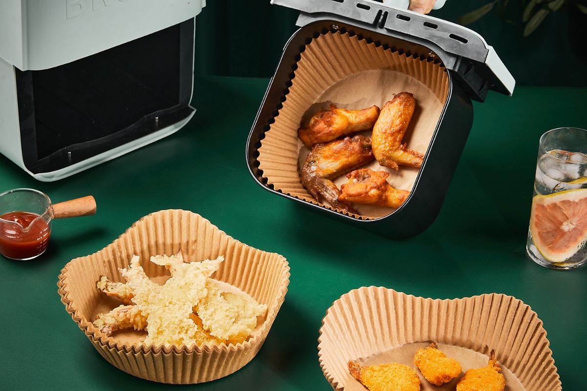 Assorted air fryer papers holding different fried dishes