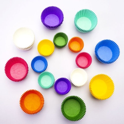 Colorful paper muffin cups on white background.