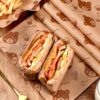 Sandwich wrapped in sandwich paper with bear print on wooden table